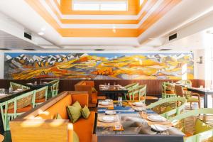 a dining room with tables and chairs and a mural at Shinta Mani Mustang - A Bensely Collection in Jomsom