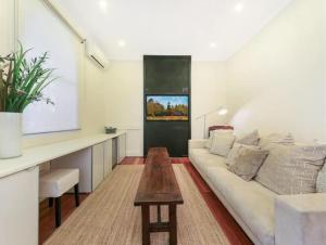 a living room with a white couch and a table at Cosy Cottage Funky ICC Darling Harbour Sydney in Sydney