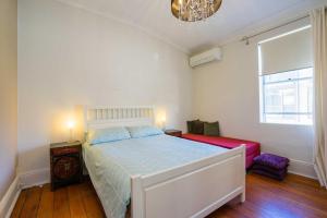 a bedroom with a white bed and a window at Cosy Cottage Funky ICC Darling Harbour Sydney in Sydney