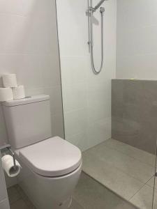 a white bathroom with a toilet and a shower at Pandanus Paradise. Newly renovated 4 bedroom home in Cabarita Beach +35 photos