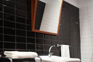 a black tiled bathroom with a sink and a mirror at Four Points Express by Sheraton Bursa Nilufer in Bursa
