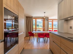 a kitchen and dining room with a table and red chairs at Appartement Les Arcs 1800, 4 pièces, 6 personnes - FR-1-352-57 in Arc 1800