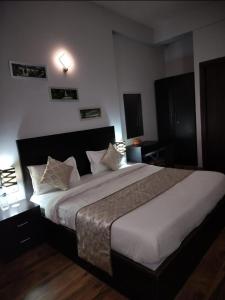 a bedroom with a large bed with white sheets and pillows at Amber suits and Hotal in Vrindāvan