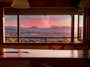 a view of a sunset through a window at Luxurious Hinterland Guest House with HEATED POOL Sleeps 10 Brisbane Scenic Rim Gold Coast in Canungra
