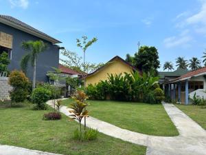 une maison avec une cour verdoyante dans l'établissement Sayang Bungalows, à Kuta Lombok