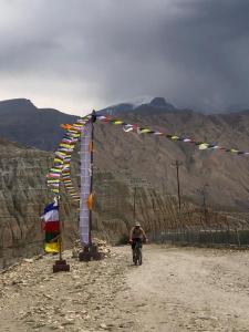 a man is riding a bike in front of a banner at Shinta Mani Mustang in Jomsom