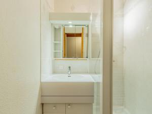 a white bathroom with a sink and a mirror at Appartement La Plagne-Tarentaise, 1 pièce, 4 personnes - FR-1-351-131 in La Plagne Tarentaise