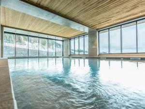 una piscina vuota con acqua in una stanza con finestre di Appartement Les Arcs 1600, 3 pièces, 6 personnes - FR-1-461A-24 ad Arc 1600