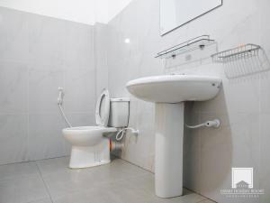 阿努拉德普勒的住宿－Family Holiday Resort，白色的浴室设有卫生间和水槽。