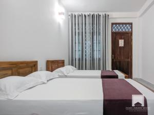 阿努拉德普勒的住宿－Family Holiday Resort，一间卧室设有两张白色的床和窗户