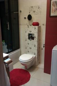 a bathroom with a toilet and a shower with a red rug at Peaceful Stay/Heart of Gdansk/Unforgettable in Gdańsk