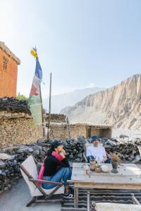 a couple of people sitting at a picnic table at Shinta Mani Mustang in Jomsom