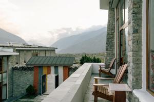 a balcony with benches and a view of mountains at Shinta Mani Mustang in Jomsom