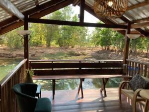 un banc sur une terrasse avec vue sur l'eau dans l'établissement Up The Farm Udon Thani Farm Stay, 