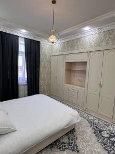 Un dormitorio con una gran cama blanca y una lámpara de araña. en Квартира Самарканд, en Samarkand