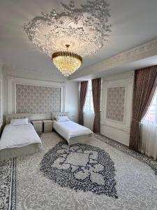 1 dormitorio con 2 camas y lámpara de araña en Квартира Самарканд, en Samarkand