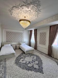 a bedroom with two beds and a chandelier at Квартира Самарканд in Samarkand