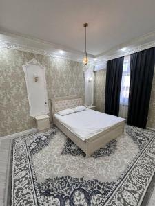a bedroom with a bed and a rug at Квартира Самарканд in Samarkand