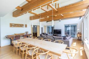 a living room with a large wooden table and chairs at Chalet Murasaki in Niseko