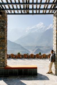 a man standing on a patio looking at a mountain at Shinta Mani Mustang in Jomsom