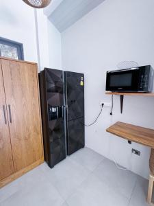 a kitchen with a refrigerator and a microwave at Tropical Bali Style House with Kitchen outside and Shared Pool in Salad Beach