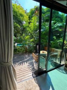a sliding glass door to a patio with a table and chairs at Tropical Bali Style House with Kitchen outside and Shared Pool in Salad Beach