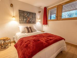 um quarto com uma cama com um cobertor vermelho em Appartement La Plagne-Tarentaise, 3 pièces, 6 personnes - FR-1-351-178 em La Plagne Tarentaise