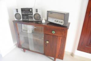 Un armario con un microondas y una radio encima. en Villa Weligama Gedara, en Weligama