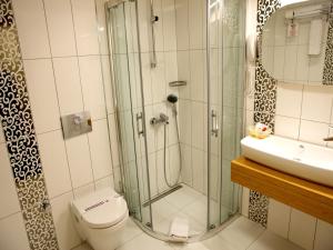 y baño con ducha, aseo y lavamanos. en Sultan Hotel, en Sivas