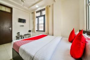 una camera da letto con un grande letto con cuscini rossi di OYO Hotel Tirupati Residency a Kota