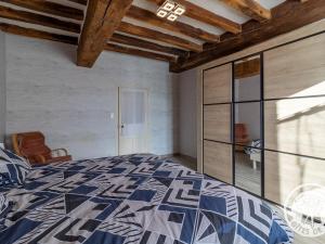 a bedroom with a bed with a blue and white comforter at Gîte Beaupréau-en-Mauges-Beaupréau, 3 pièces, 5 personnes - FR-1-622-73 