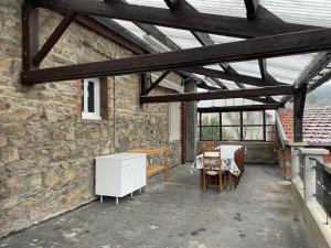 eine Terrasse mit einem Tisch und einer Steinmauer in der Unterkunft Gîte Ferrières-sur-Sichon, 6 pièces, 10 personnes - FR-1-489-497 in Ferrières-sur-Sichon
