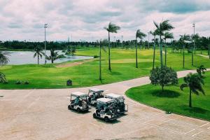 uma vista aérea de um campo de golfe com dois carrinhos de golfe em Nhà Thô Nguyên Căn Đảo Swan Bay em Phước Lý