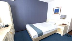 大阪的住宿－新大阪心齋橋酒店，一间卧室配有一张蓝色墙壁的床