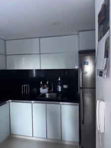 a small kitchen with a sink and a refrigerator at Cali Valle del Lili Apartamento in Cali