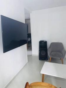 een woonkamer met een tv en een stoel en een tafel bij Cali Valle del Lili Apartamento in Cali