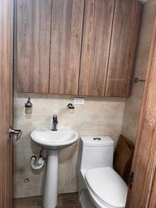 ein Badezimmer mit einem weißen WC und einem Waschbecken in der Unterkunft Cali Valle del Lili Apartamento in Cali