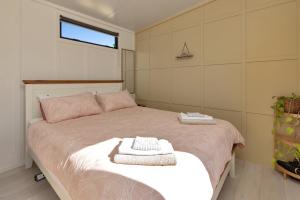 a bedroom with a bed with two towels on it at Valley View - Whangarei Tiny Home in Whangarei