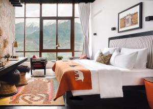 a bedroom with a bed and a large window at Shinta Mani Mustang in Jomsom