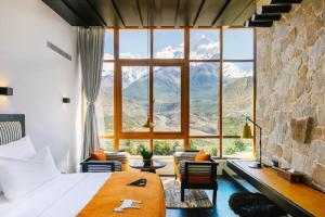 a bedroom with a large window and mountains at Shinta Mani Mustang in Jomsom