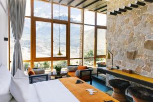 a bedroom with a bed and a stone wall at Shinta Mani Mustang in Jomsom