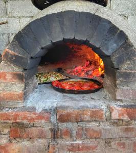 a brick oven with a dish of food in it at Huaka Hostal in Cafayate