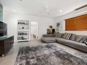 a living room with a couch and a tv at Beach House on Pearl - Kingscliff Central in Kingscliff