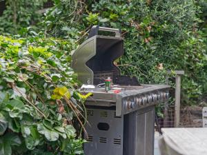 una parrilla al aire libre con una bebida en su interior en Kiwi Charmer - Onemana Holiday Home, en Opoutere