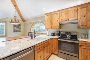 a kitchen with wooden cabinets and a sink at Lulu City 6K by AvantStay Condo in Great Location Close to Skiing Downtown in Telluride