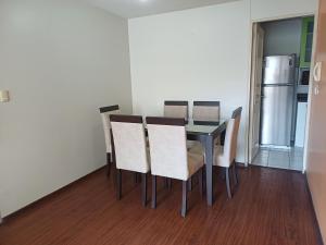 uma sala de jantar com uma mesa e cadeiras e um frigorífico em Habitación acogedora Orué em Lima