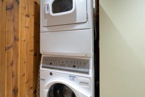 a white washing machine with a microwave on top of it at Lulu City 6K by AvantStay Condo in Great Location Close to Skiing Downtown in Telluride