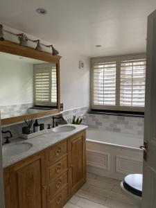 a bathroom with two sinks and a bath tub at Grand Victorian family home - nestled between woodland and beach in Haven Street
