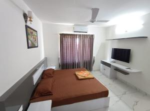 a small room with a bed and a television at Heaven vantage point in Trivandrum