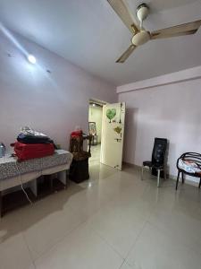 a living room with a ceiling fan and a room with a couch at rajul flats adarsh nagar jabalpur in Jabalpur